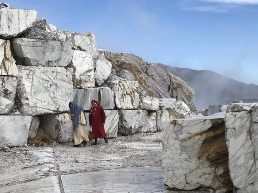 Two people walking in a marble quarry.