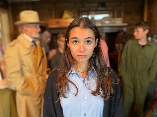 Young woman in focus, others blurred behind.
