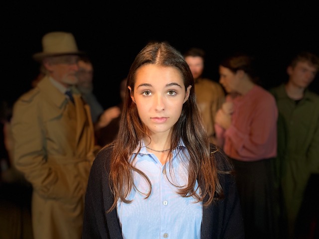 Young woman standing among blurred people.