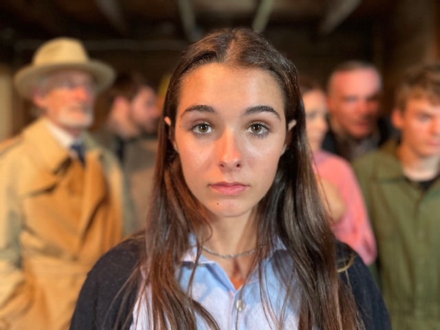 Young woman standing in front of group.