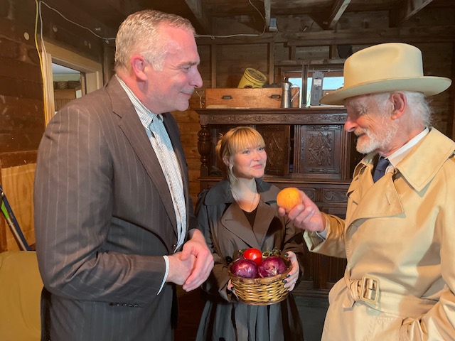 Three people with apples in rustic setting.